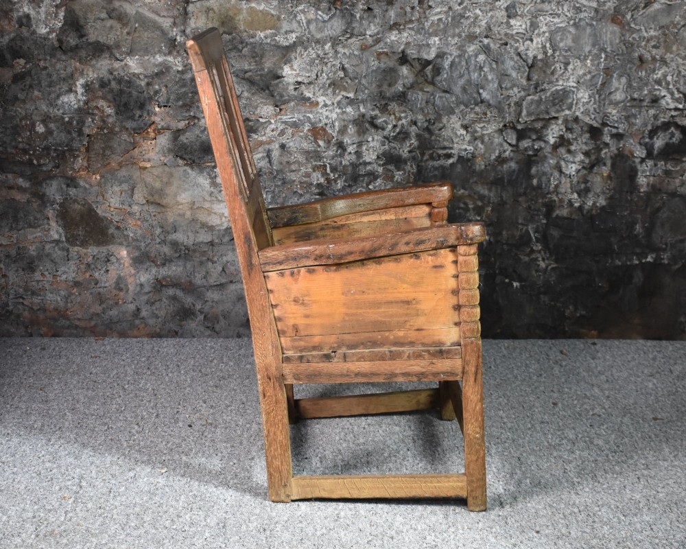 An 18th-century Scottish crofter armchair featuring turned front arm posts, panelled sides, and a slatted back in a warm wood finish. View VIII