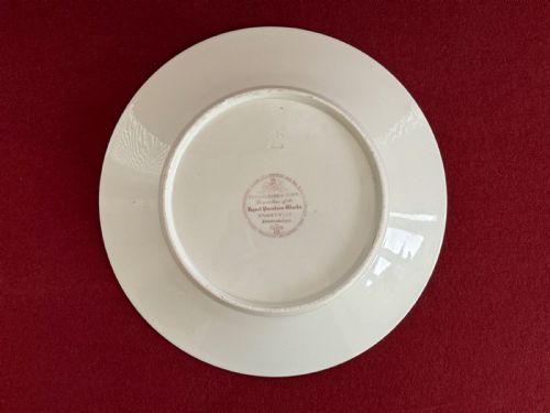 fig 1. A circular green porcelain plate featuring hand-painted floral cartouches surrounded by gilded rococo scrollwork and central floral and butterfly vignettes.