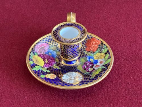 fig 1. A Regency period Spode porcelain chamber candlestick decorated with a cobalt blue scale pattern, gilt trim, and hand-painted floral panels.