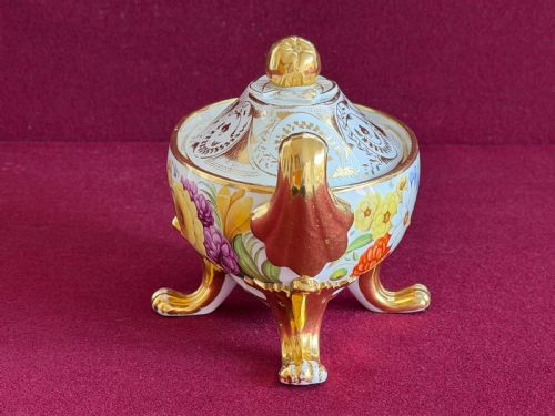 fig 1. A Regency John Rose Coalport porcelain sauce tureen decorated with hand-painted flowers, gilded scroll handles, and a matching lid.