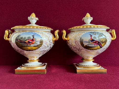 fig 1. A pair of Regency Flight, Barr & Barr Worcester porcelain cream tureens featuring hand-painted exotic bird panels, elaborate gilding, twin scroll handles, and square plinth bases.