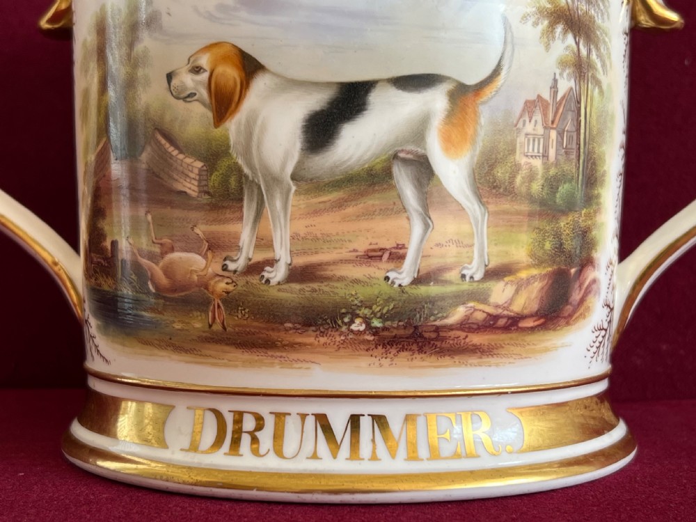 A Victorian English porcelain loving cup featuring two gilded scroll handles and a hand-painted hound named Drummer in a rural setting. View IV
