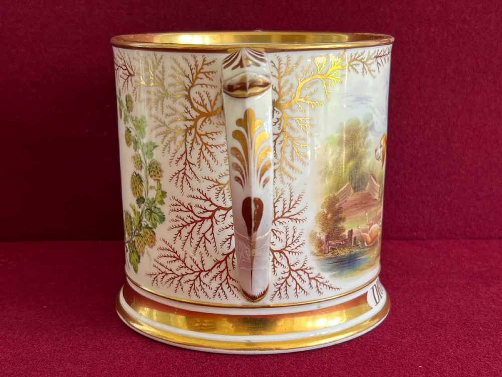A Victorian English porcelain loving cup featuring two gilded scroll handles and a hand-painted hound named Drummer in a rural setting. View V