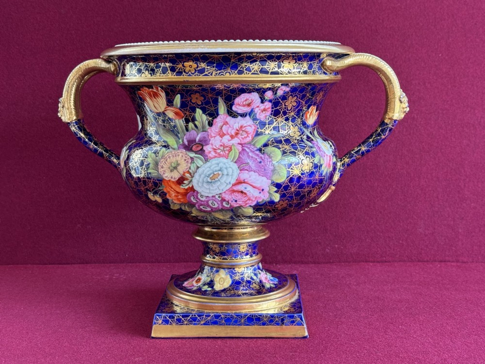 A cobalt blue Regency porcelain Warwick-style urn decorated with hand-painted floral bouquets, gold gilding, twin gilded handles, and a square pedestal base. View III