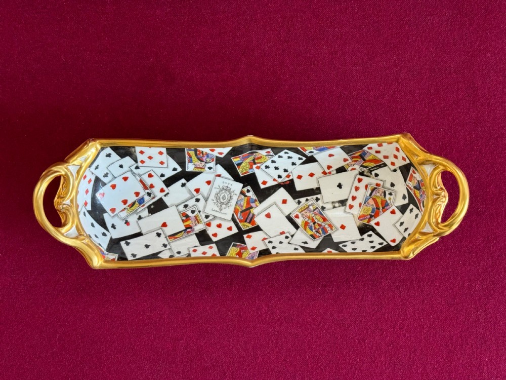 An elongated Regency period Derby porcelain pen tray decorated with hand-painted playing card motifs and featuring gilded scroll handles.