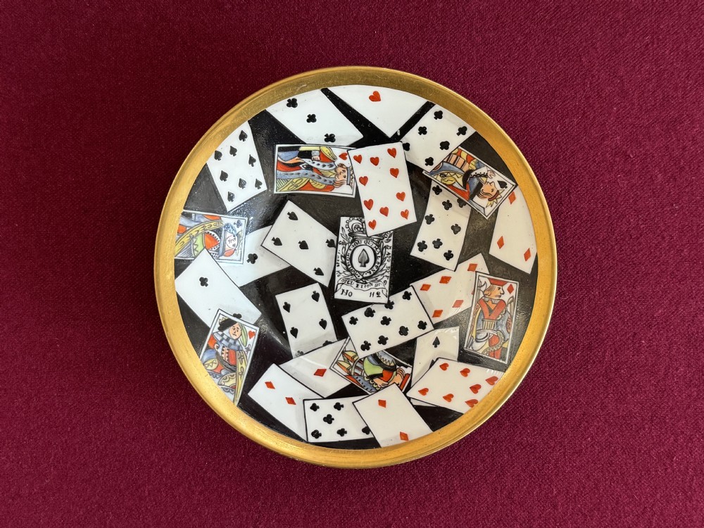 An antique Regency period porcelain teacup and matching saucer featuring a hand-painted playing card motif on the interior and a gilded exterior finish. View V