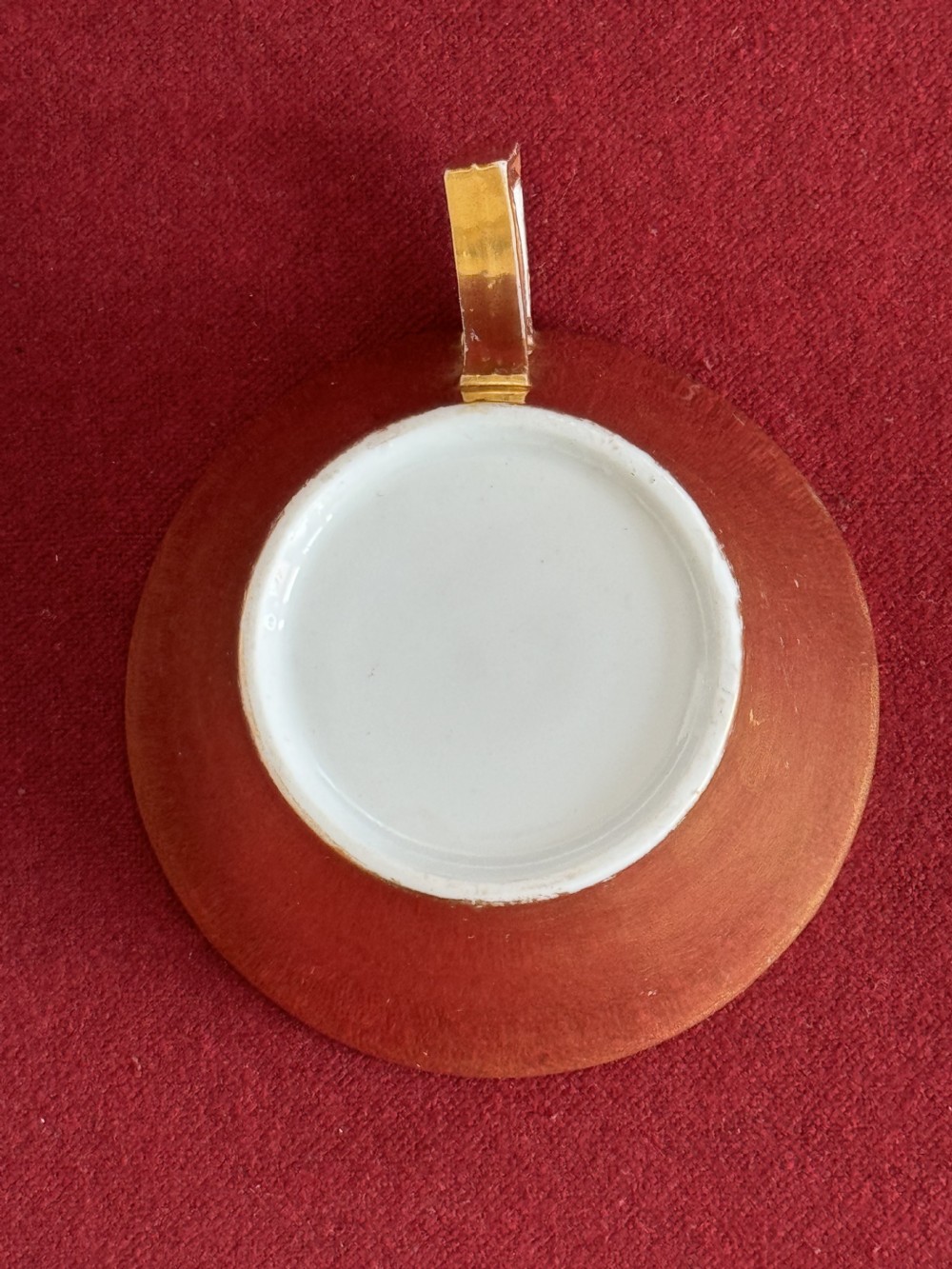 An antique Regency period porcelain teacup and matching saucer featuring a hand-painted playing card motif on the interior and a gilded exterior finish. View VI