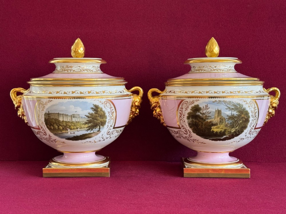 A pair of Regency Flight, Barr and Barr Worcester porcelain ice pails decorated with pink borders, gilded lion mask handles, and hand-painted landscape scenes.