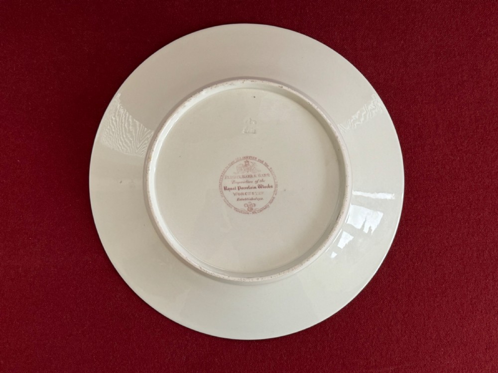A circular green porcelain plate featuring hand-painted floral cartouches surrounded by gilded rococo scrollwork and central floral and butterfly vignettes. View II