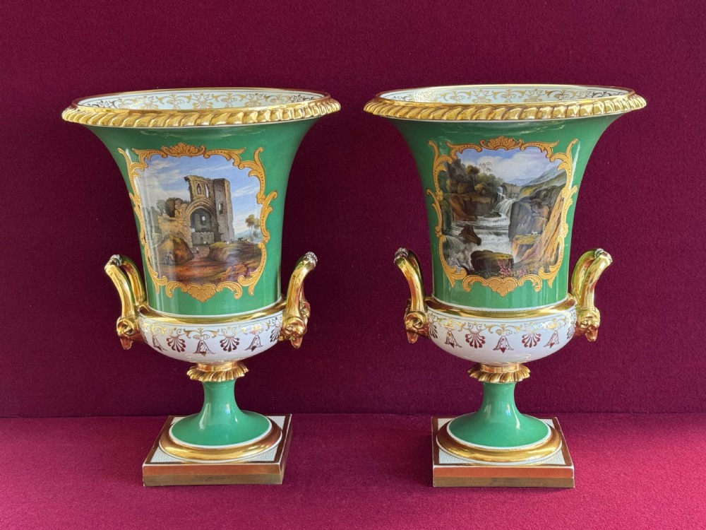 A pair of Regency porcelain urn vases featuring apple green grounds, gilt goat-head handles, and central hand-painted landscape scenes. View II