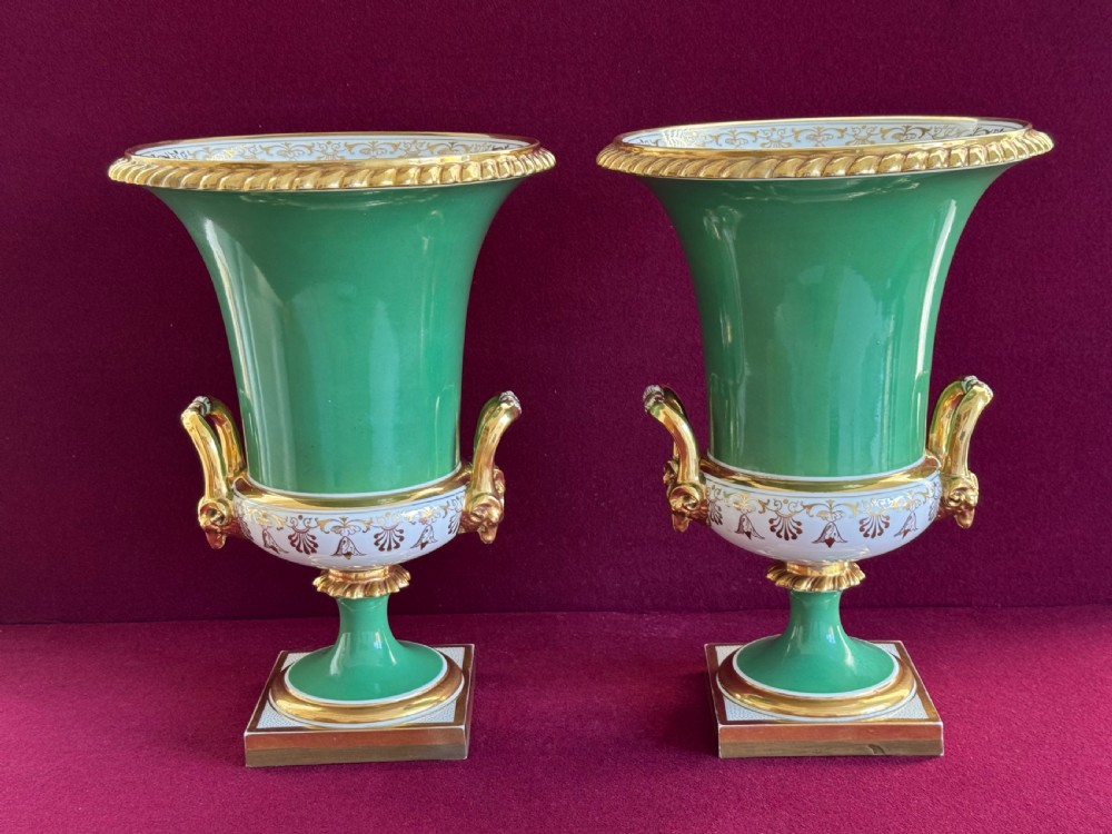 A pair of Regency porcelain urn vases featuring apple green grounds, gilt goat-head handles, and central hand-painted landscape scenes. View VII