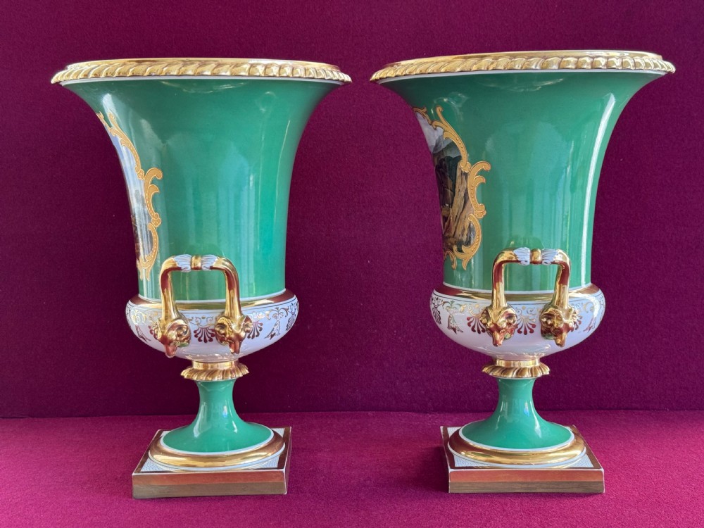 A pair of Regency porcelain urn vases featuring apple green grounds, gilt goat-head handles, and central hand-painted landscape scenes. View IX