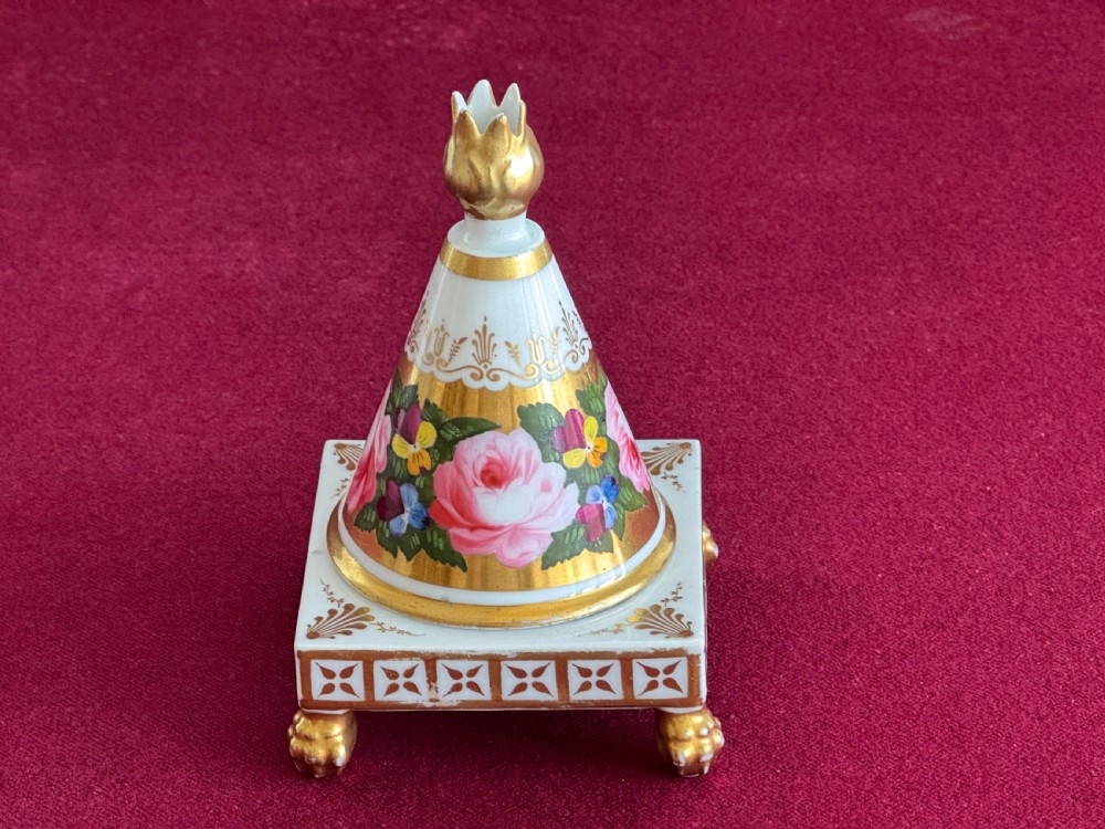 A conical Regency porcelain pastille burner decorated with hand-painted pink roses and pansies on a square gilded pedestal with claw feet.