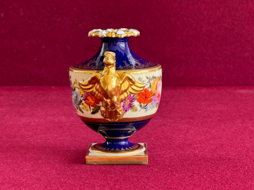 A Regency Flight, Barr and Barr Worcester porcelain rose water sprinkler featuring a cobalt blue ground, hand-painted floral band, zoomorphic gilded spout, and loop handle on a square pedestal base. View IV