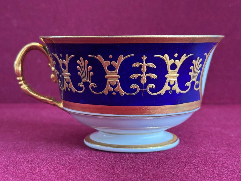 A Flight, Barr and Barr Worcester porcelain cup and saucer featuring cobalt blue ground, gilt palmette borders, and the Prince of Wales crest. View VIII