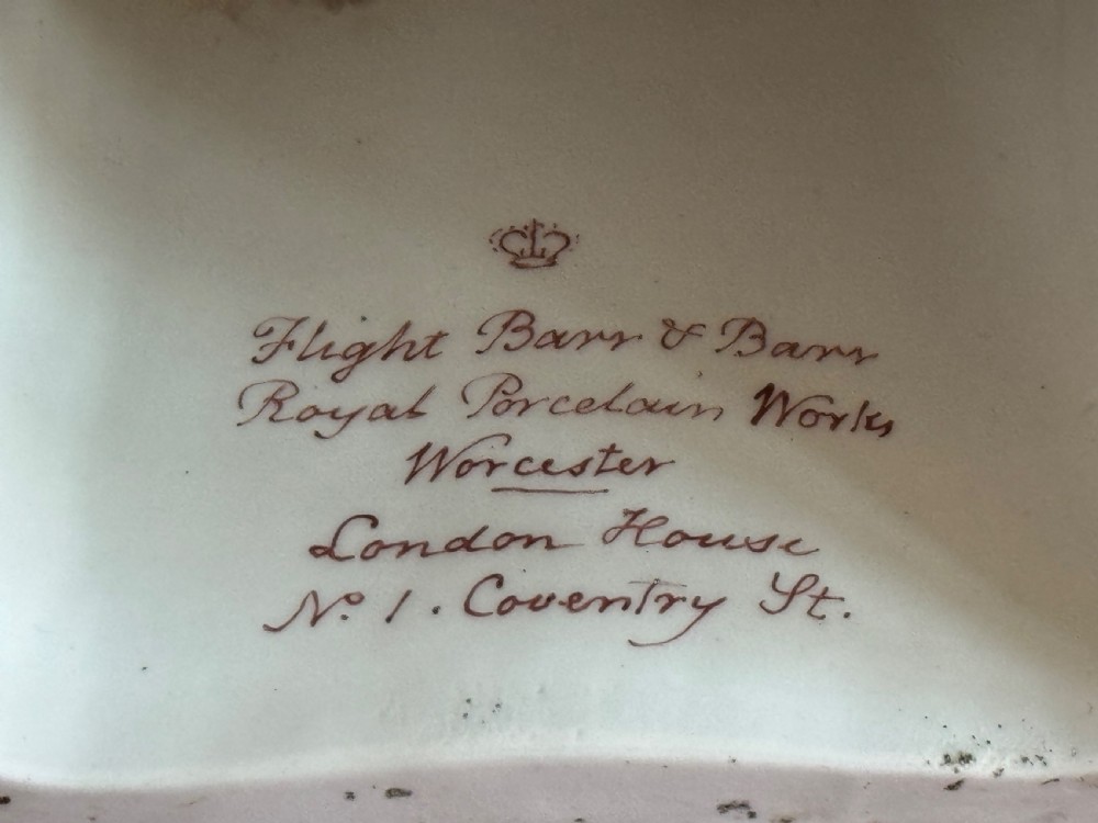 A three-piece Flight, Barr and Barr Worcester porcelain garniture set with hand-painted landscape scenes, pink ground borders, and gilded scroll handles resting on square pedestal bases. View VI