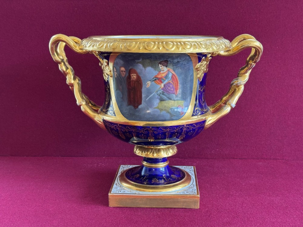 A Regency Flight, Barr and Barr Worcester cobalt blue porcelain Warwick urn featuring twin gilt vine-twisted handles, intricate gilt tooling, and a central hand-painted panel depicting two figures in a landscape. View III