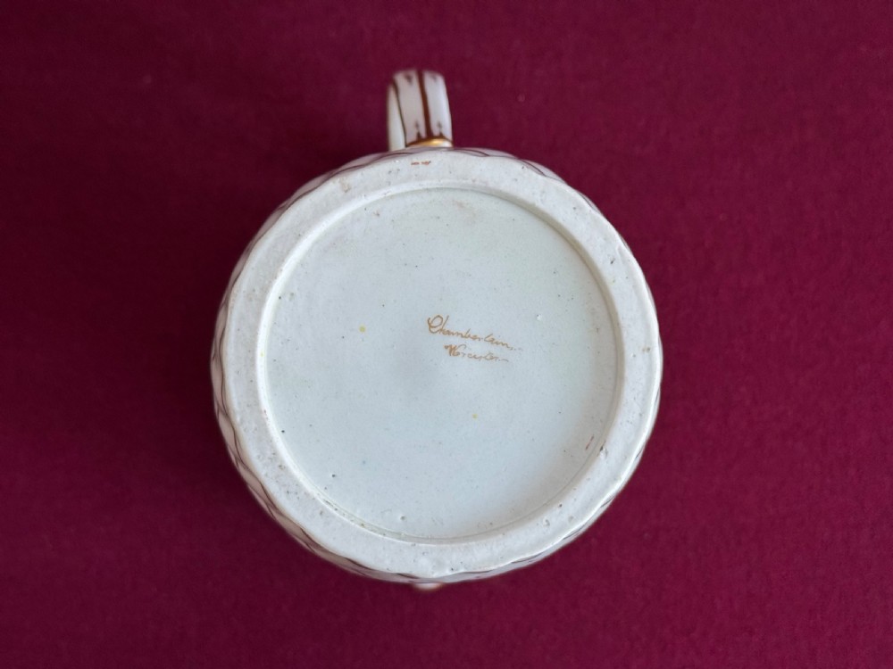 A white and yellow antique porcelain jug decorated with gilt detailing, spiral fluting, and a central armorial crest featuring a painted lion. View VI