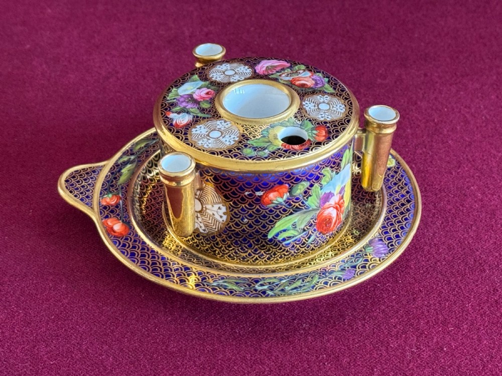 An early 19th-century circular English porcelain inkstand featuring gold scale gilding on a dark blue ground, floral reserves, and three cylindrical quill holders. View III