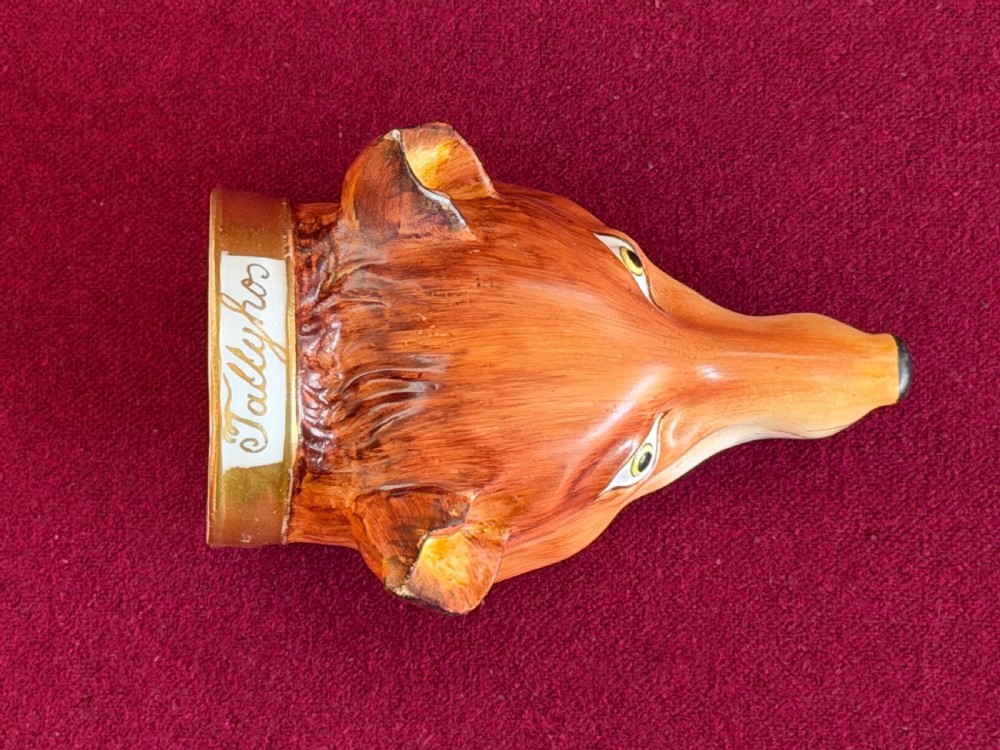 An antique porcelain stirrup cup moulded in the form of a fox head with hand-painted details and a gilded rim inscribed with Tallyho. View IV