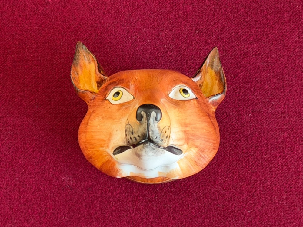 An antique porcelain stirrup cup moulded in the form of a fox head with hand-painted details and a gilded rim inscribed with Tallyho. View VI