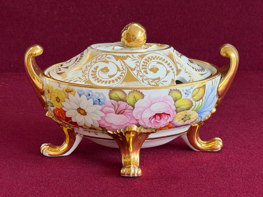A Regency John Rose Coalport porcelain sauce tureen decorated with hand-painted flowers, gilded scroll handles, and a matching lid.