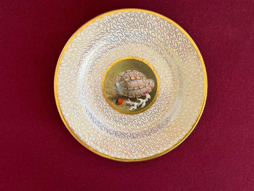 A pair of circular Regency porcelain cabinet plates featuring hand-painted seashell central motifs surrounded by gilded vermicelli pattern borders. View II
