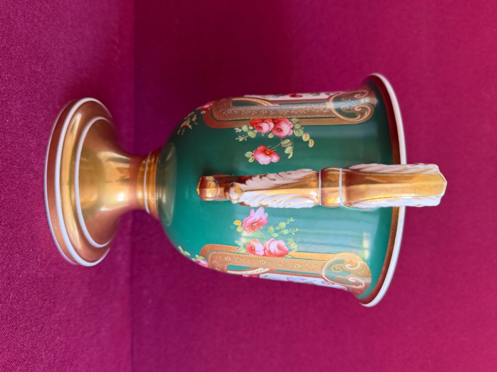 A two-handled green porcelain cup decorated with gold gilding and a hand-painted fruit and floral cartouche on a pedestal foot. View IV