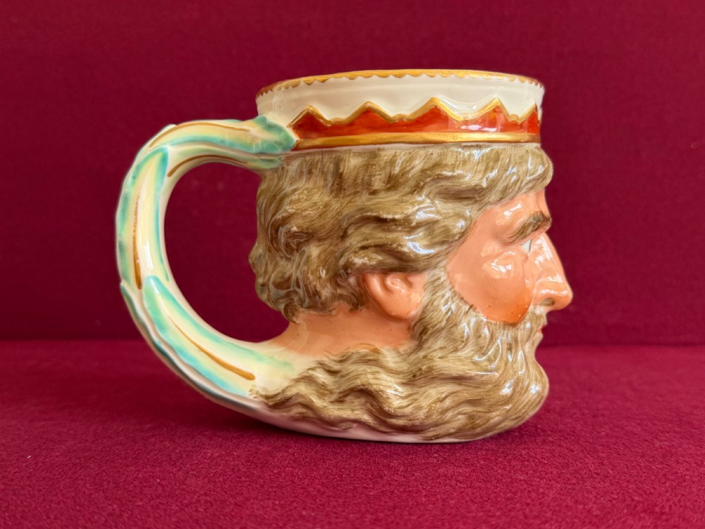 An 18th-century Derby porcelain mug sculpted in the shape of Neptunes head with a painted beard, skin tones, and a red and gold crown rim. View IV