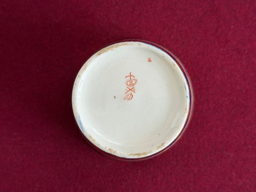 A pair of tapered porcelain beakers featuring a hand-painted floral rose band positioned between cobalt blue borders decorated with gold lattice gilding. View IV