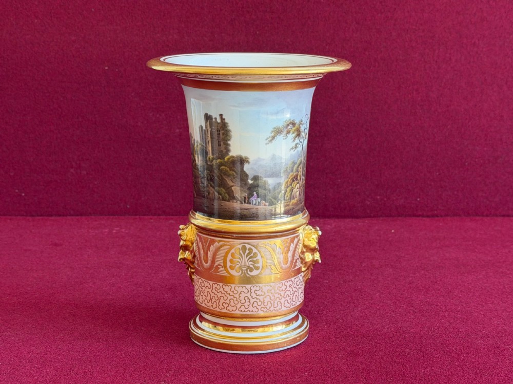 A Regency Barr, Flight and Barr Worcester porcelain spill vase featuring a hand-painted landscape panel of Ballyhooly Castle, gold lion-mask side handles, and gilt classical ornamentation.