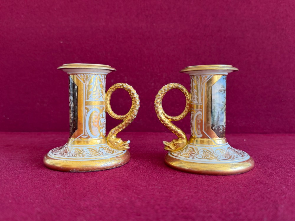A pair of early nineteenth-century porcelain candlesticks featuring hand-painted landscape scenes on the shafts and detailed gilding on the bases. View III
