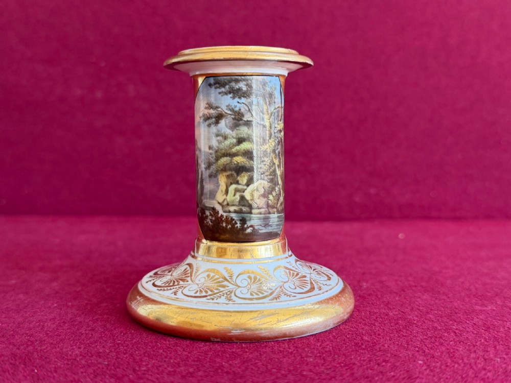 A pair of early nineteenth-century porcelain candlesticks featuring hand-painted landscape scenes on the shafts and detailed gilding on the bases. View V