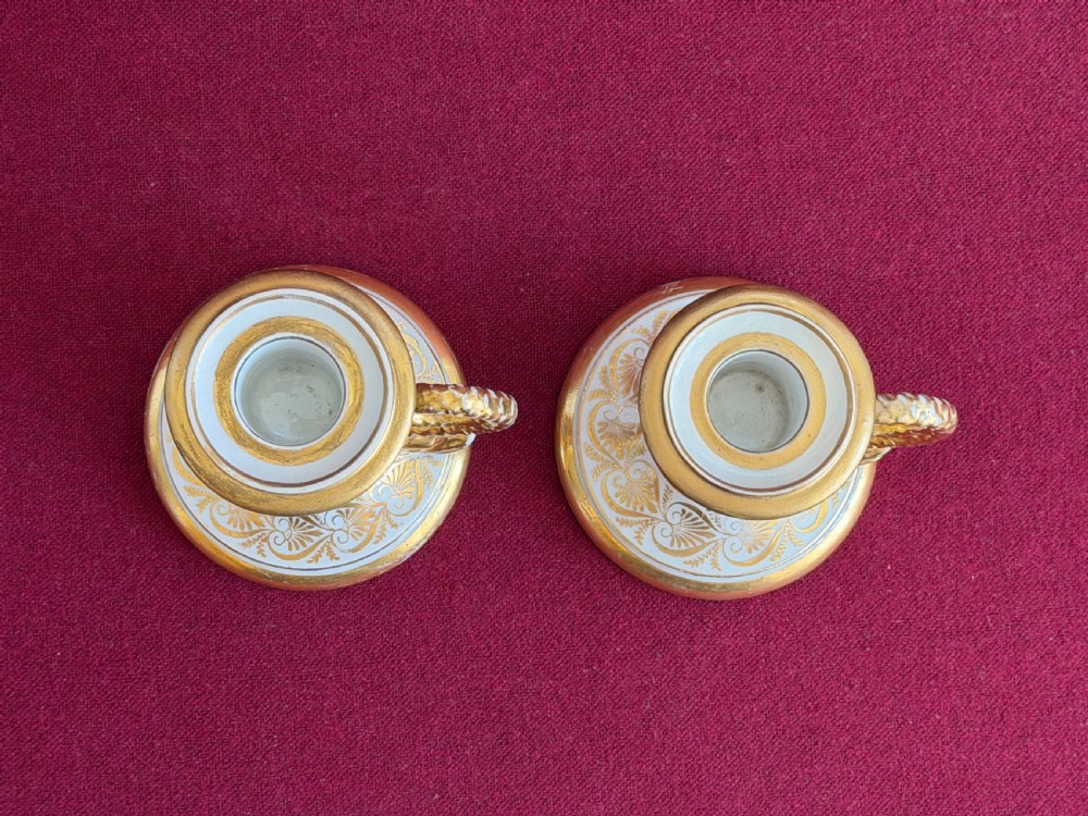 A pair of early nineteenth-century porcelain candlesticks featuring hand-painted landscape scenes on the shafts and detailed gilding on the bases. View VIII