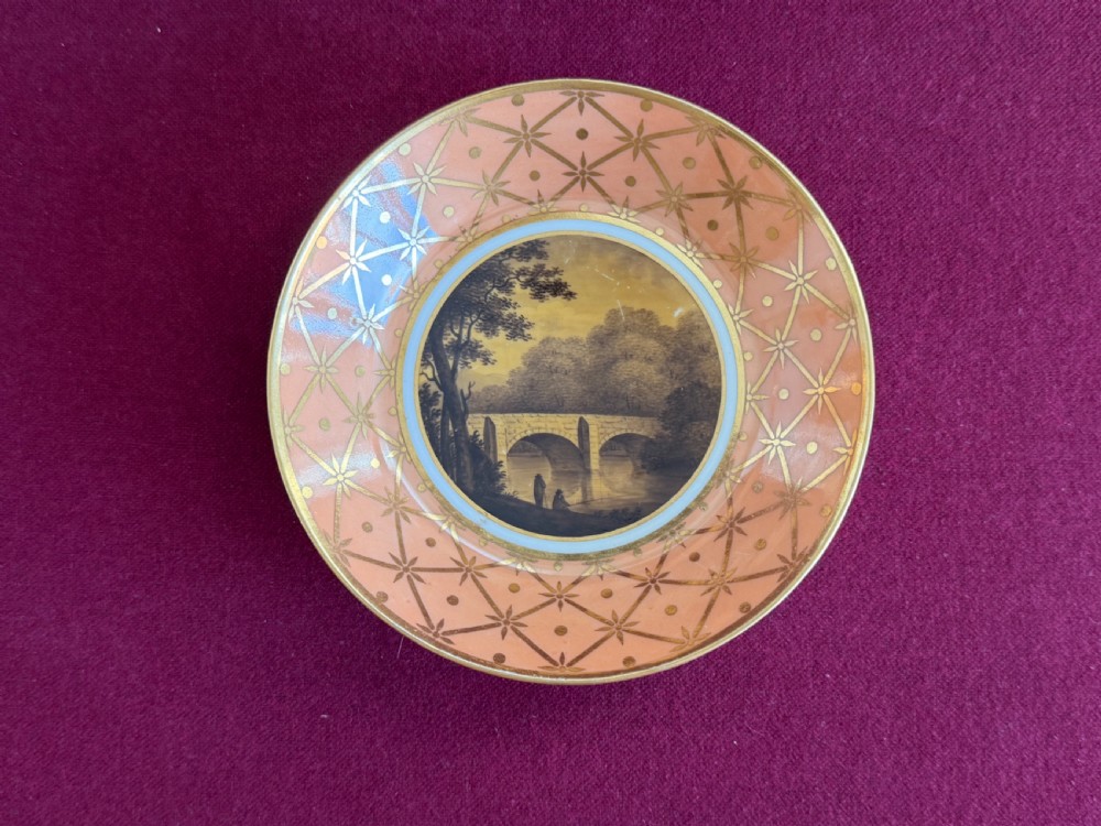 A Georgian Flight and Barr Worcester porcelain coffee can and saucer with hand-painted sepia landscape vignettes and gilt star patterning on a peach border. View II