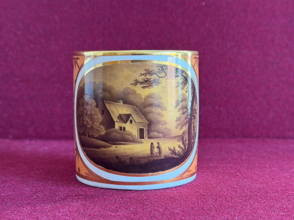 A Georgian Flight and Barr Worcester porcelain coffee can and saucer with hand-painted sepia landscape vignettes and gilt star patterning on a peach border. View V