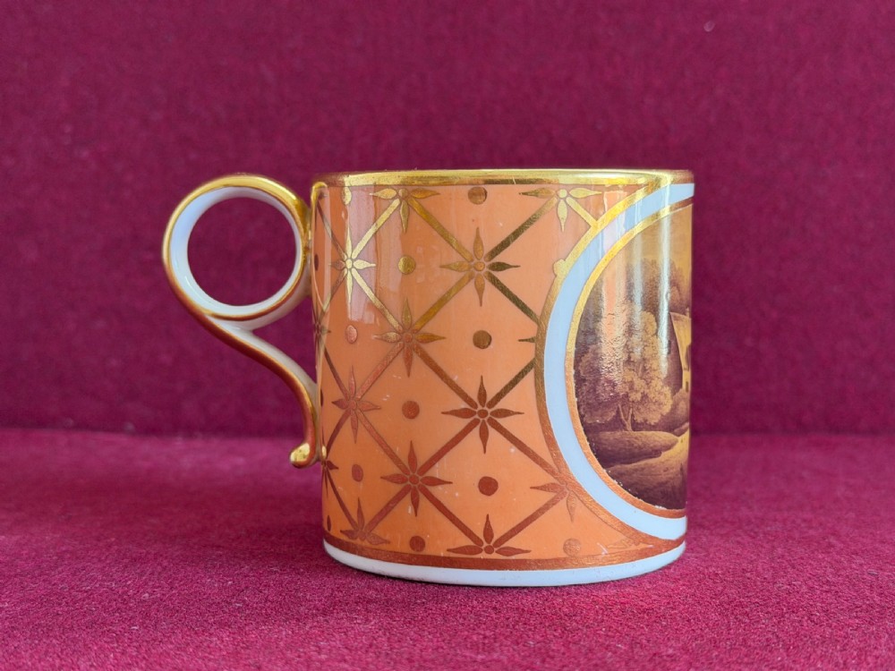 A Georgian Flight and Barr Worcester porcelain coffee can and saucer with hand-painted sepia landscape vignettes and gilt star patterning on a peach border. View VI