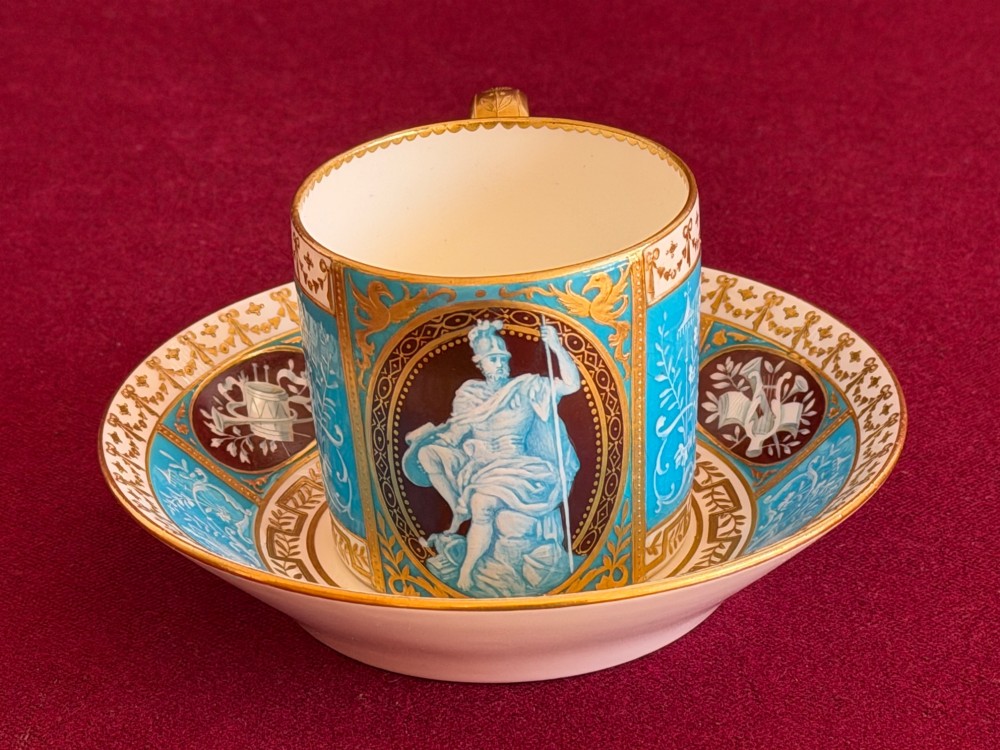 A Victorian Minton porcelain coffee can and saucer decorated with rich turquoise enamel, Neoclassical motifs, classical figure cameos, and gold leaf gilding. View II