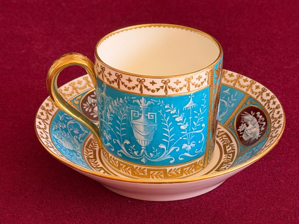 A Victorian Minton porcelain coffee can and saucer decorated with rich turquoise enamel, Neoclassical motifs, classical figure cameos, and gold leaf gilding. View V