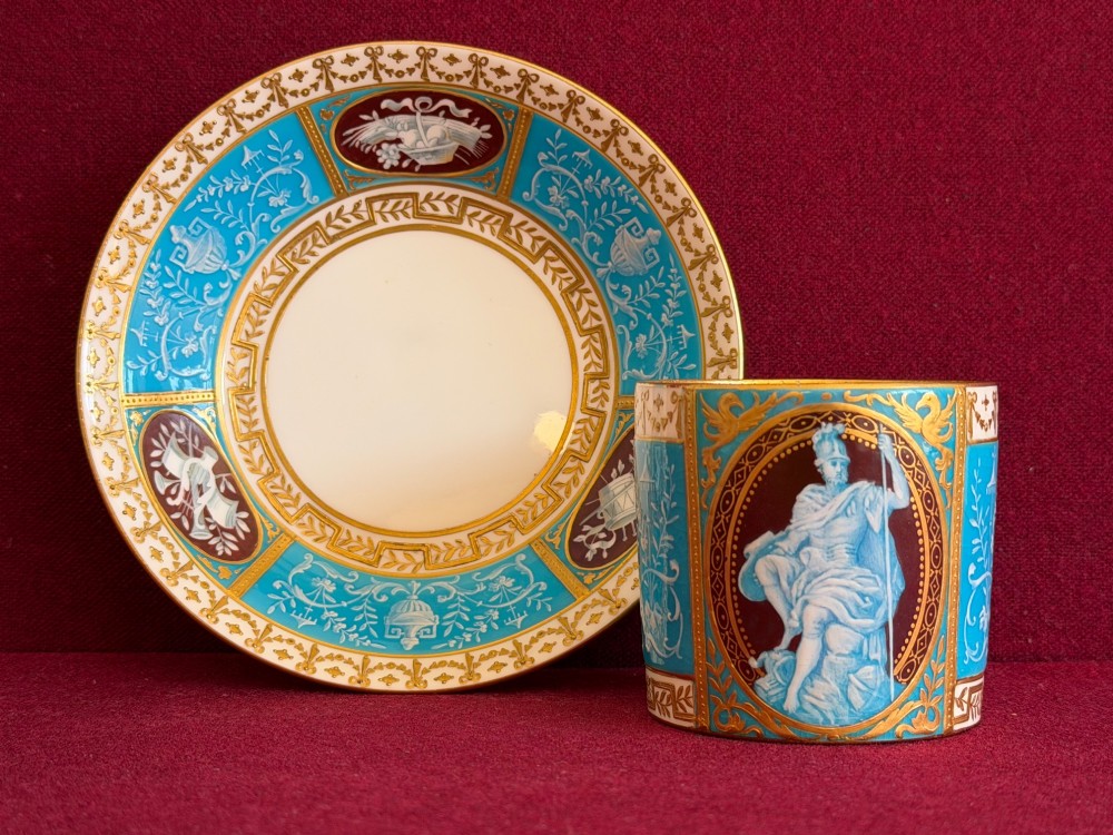 A Victorian Minton porcelain coffee can and saucer decorated with rich turquoise enamel, Neoclassical motifs, classical figure cameos, and gold leaf gilding. View IX