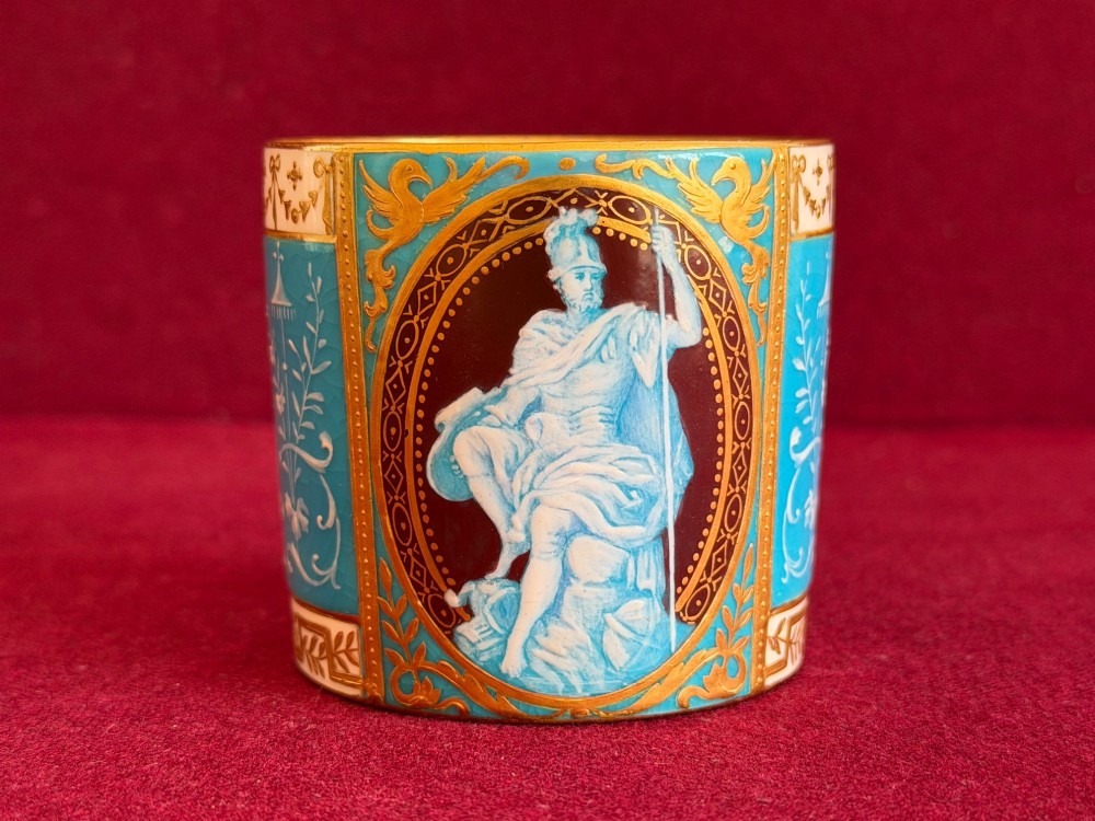 A Victorian Minton porcelain coffee can and saucer decorated with rich turquoise enamel, Neoclassical motifs, classical figure cameos, and gold leaf gilding. View X