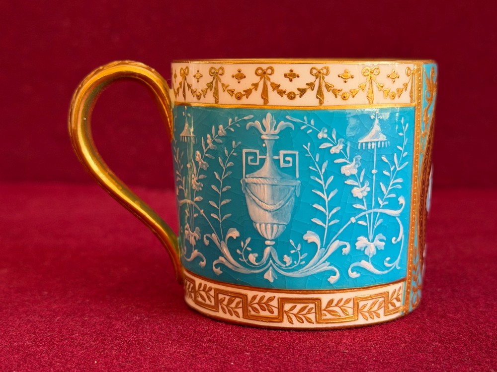 A Victorian Minton porcelain coffee can and saucer decorated with rich turquoise enamel, Neoclassical motifs, classical figure cameos, and gold leaf gilding. View XIII