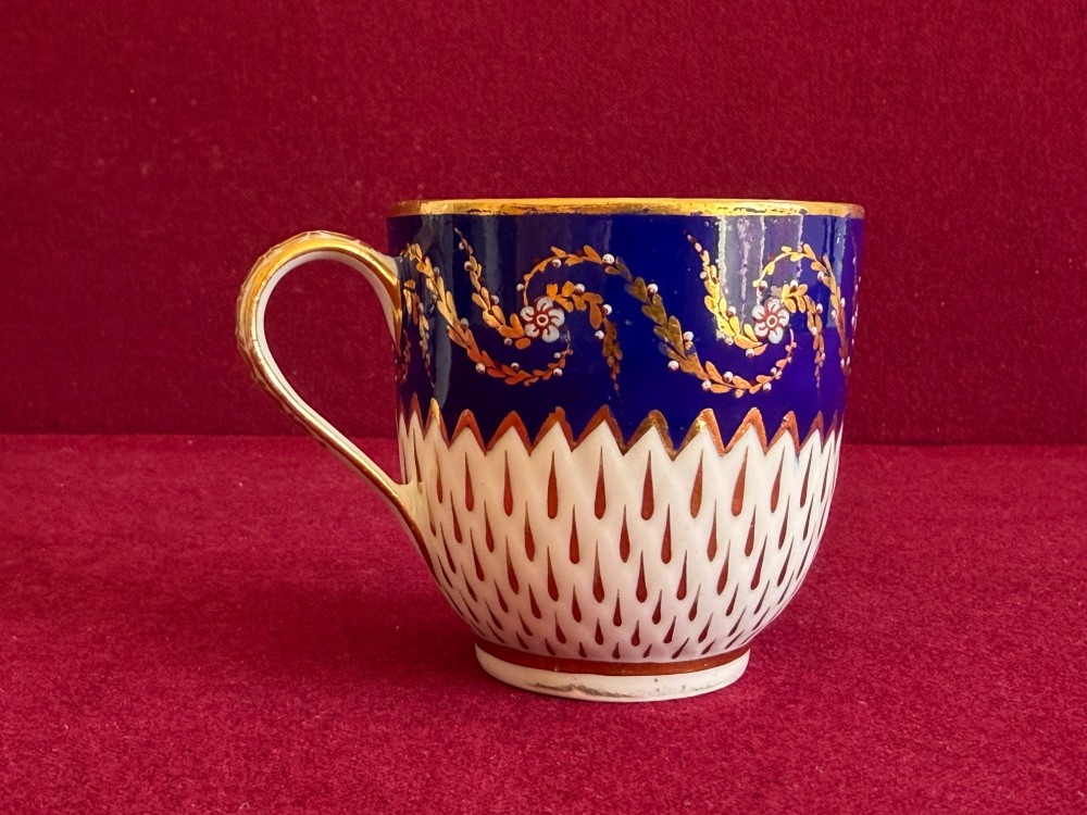 An eighteenth-century Chelsea Derby porcelain trio comprising a coffee cup, tea bowl, and saucer decorated in cobalt blue and gold leaf pattern 34. View VI
