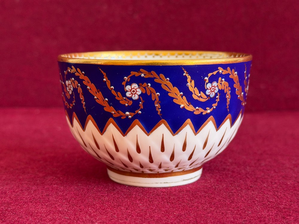 An eighteenth-century Chelsea Derby porcelain trio comprising a coffee cup, tea bowl, and saucer decorated in cobalt blue and gold leaf pattern 34. View VII