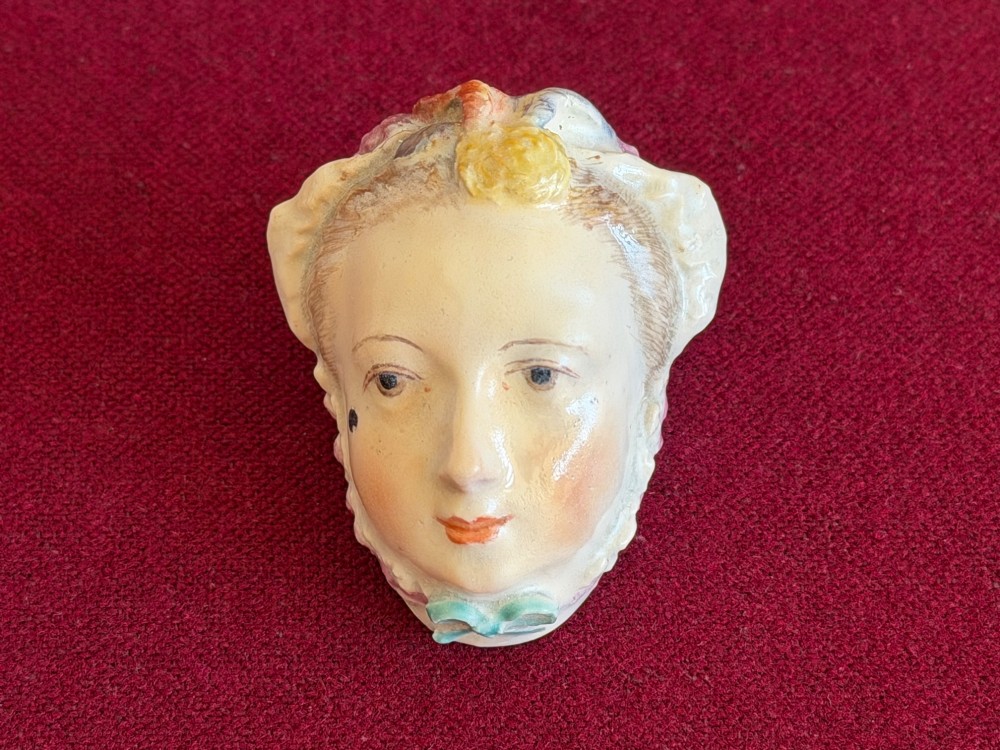 An 18th-century Chelsea soft-paste porcelain bonbonniere sculpted as a female head wearing a bonnet with polychrome enamel finish.