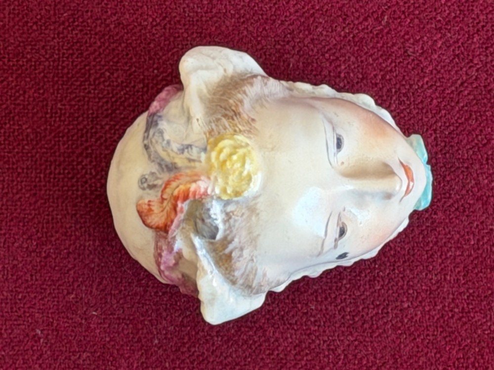 An 18th-century Chelsea soft-paste porcelain bonbonniere sculpted as a female head wearing a bonnet with polychrome enamel finish. View V