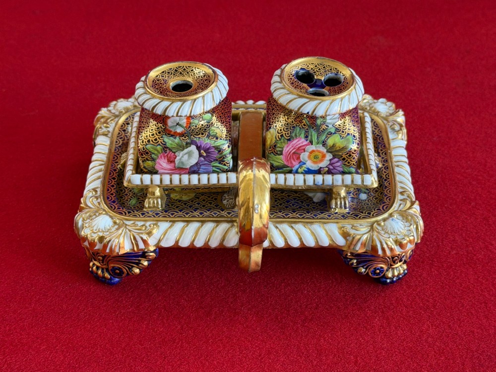 A Regency porcelain inkstand featuring elaborate gilding over a dark blue ground with polychrome floral panels and a central handle. View III