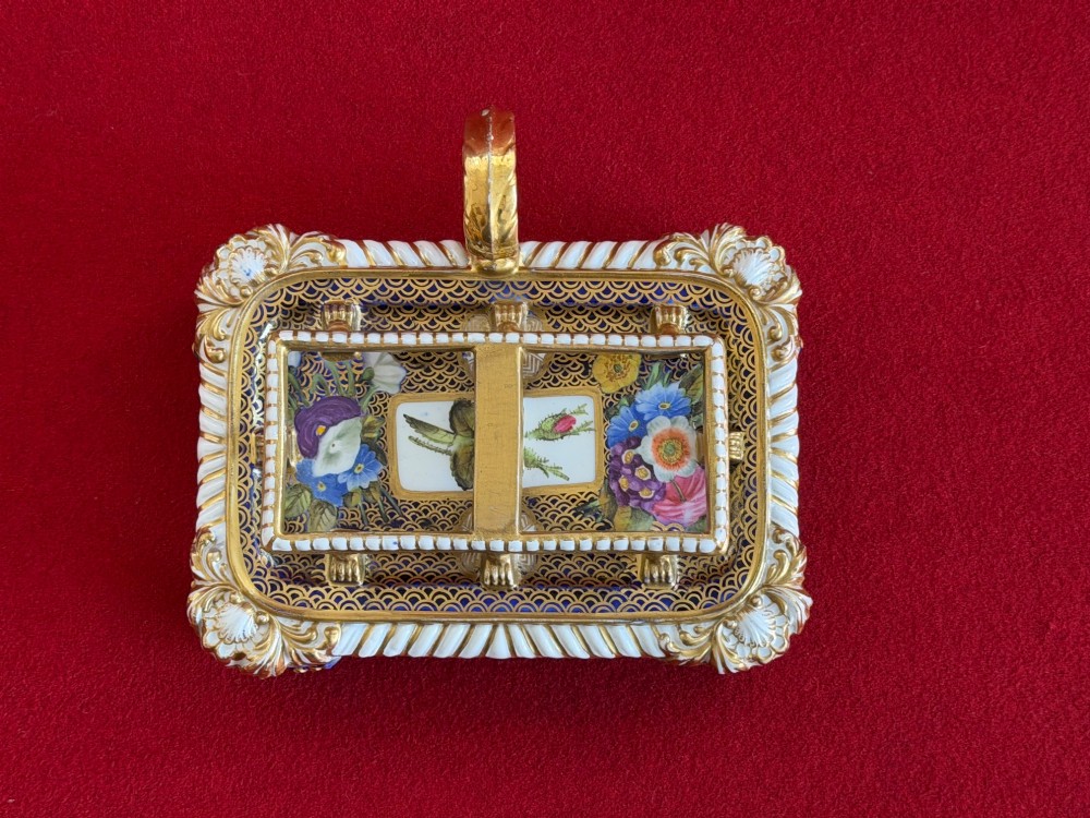 A Regency porcelain inkstand featuring elaborate gilding over a dark blue ground with polychrome floral panels and a central handle. View V
