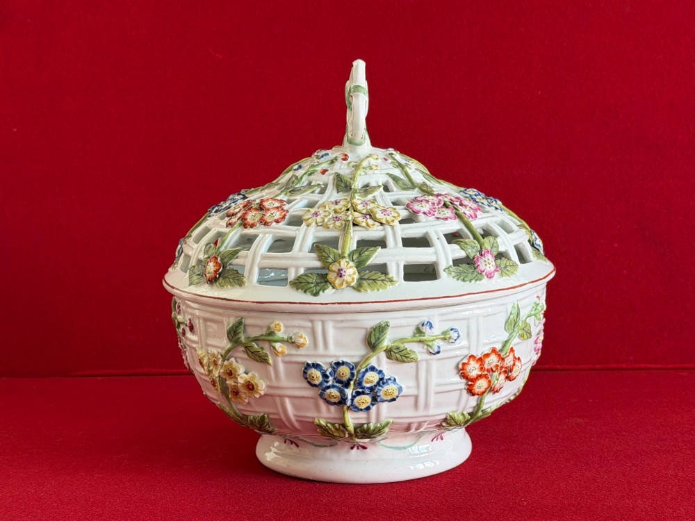 An 18th-century white soft-paste porcelain chestnut basket and domed cover featuring pierced lattice work, hand-applied colourful flowers, green leaves, and a twisted ribbon knop. View II