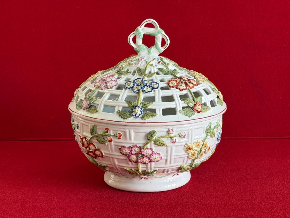 An 18th-century white soft-paste porcelain chestnut basket and domed cover featuring pierced lattice work, hand-applied colourful flowers, green leaves, and a twisted ribbon knop. View III
